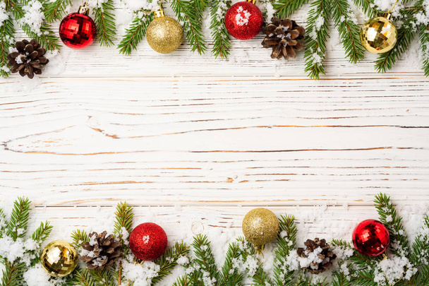 Sfondo natalizio in legno con rami di abete, pigne, neve e decorazioni. Vista dall'alto con spazio di copia
. - Foto, immagini