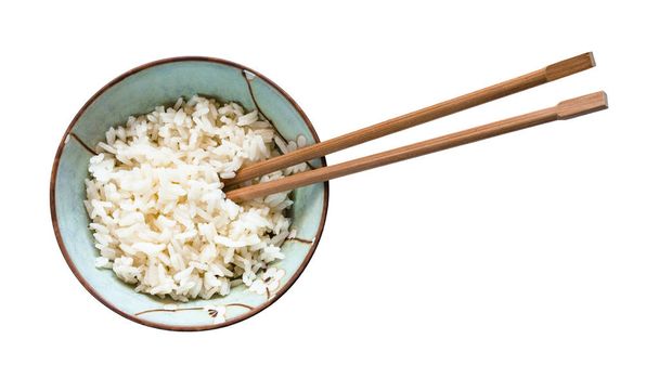 ylhäältä näkymä syömäpuikot kulhoon keitettyä riisiä eristetty valkoisella pohjalla
 - Valokuva, kuva