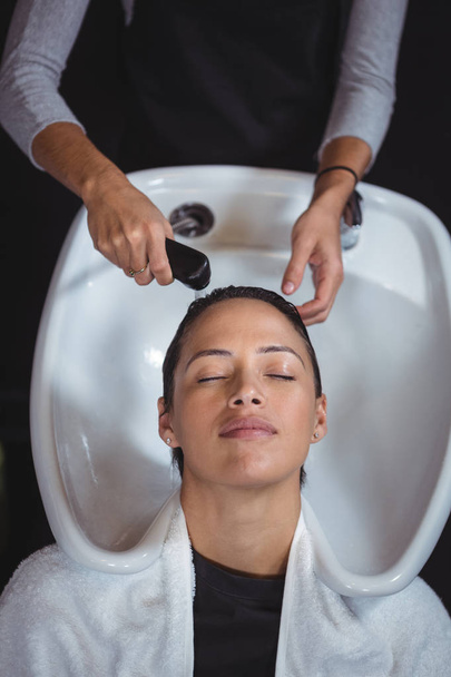 Женщина моет волосы в салоне
 - Фото, изображение