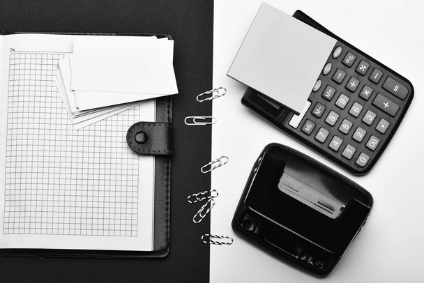 Calculator, note paper, hole punch and paper clips opposite organizer - Fotografie, Obrázek