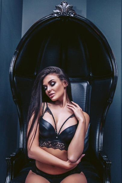 Passionate brunette in lingerie sits on a chair - Zdjęcie, obraz