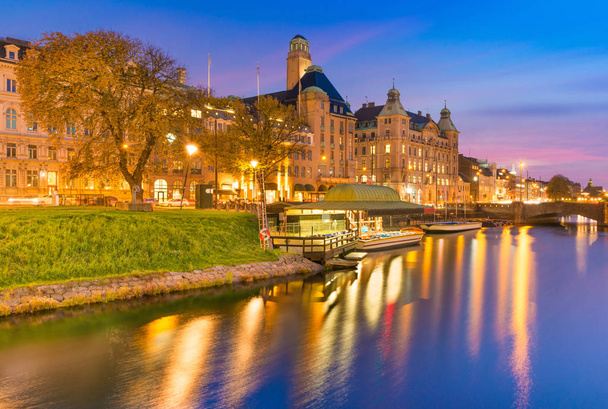 Beautiful sunset in Malmo, Sweden. Picturesque evening cityscape. Old historical buildings, canal with boats at the wharf, colorful reflections in water - Photo, Image