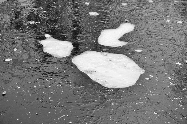 Donkere ijs oppervlak met bevroren scherpe stukjes ijs. - Foto, afbeelding
