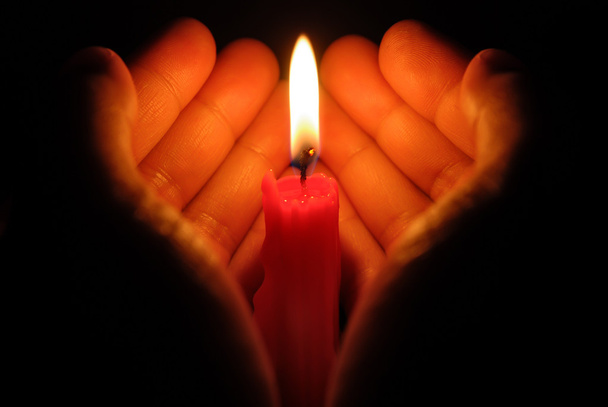 hands holding a burning candle in dark - Photo, Image