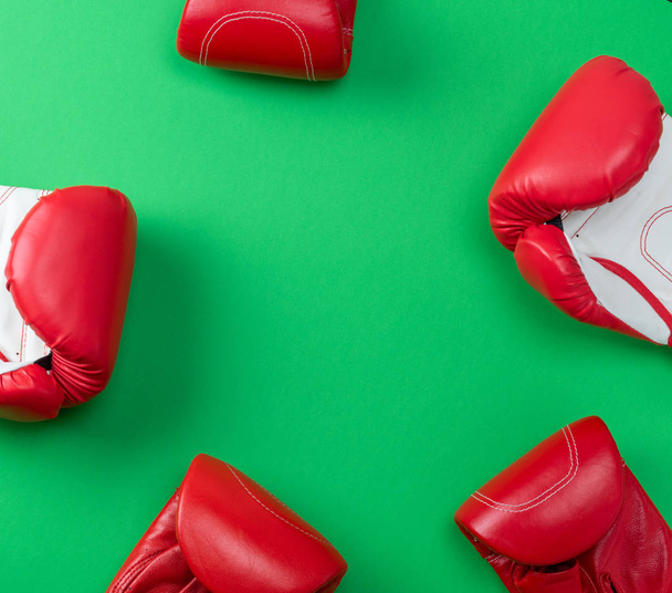 abstract green background with red leather boxing gloves, empty space in the middle - Φωτογραφία, εικόνα