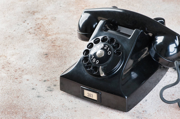 Antique μαύρο περιστροφικό τηλέφωνο σε συγκεκριμένα φόντο. Χώρο αντίγραφο για το κείμενο. - Φωτογραφία, εικόνα