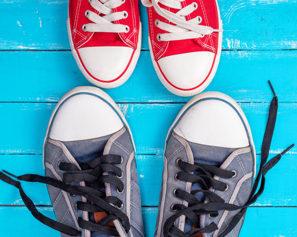 iki eski mavi ahşap arka plan, üstten görünüm üzerinde tekstil spor ayakkabı çiftleri - Fotoğraf, Görsel
