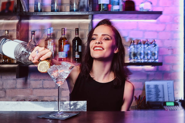 Красива дівчина бармен готує алкогольний коктейль з горілкою
 - Фото, зображення