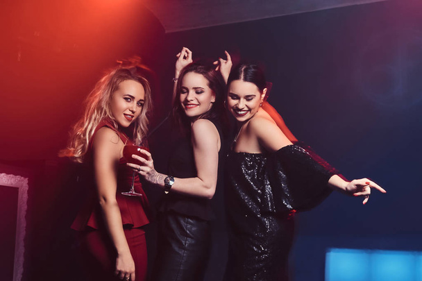Beautiful elegantly dressed female friends have fun at the nightclub - Φωτογραφία, εικόνα