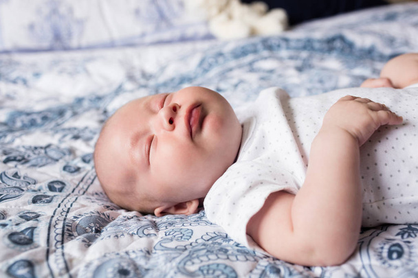 Bebé durmiendo con maniquí en la boca en la cama en casa
 - Foto, imagen