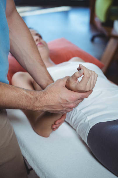 Physiotherapeut massiert Hand einer Patientin in Klinik - Foto, Bild