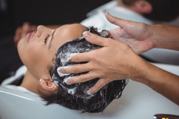 Женщина моет волосы в салоне
 - Фото, изображение