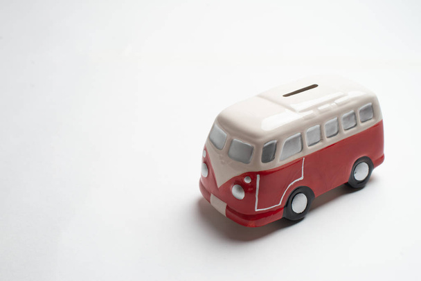Red bus moneybox with coins. - Foto, imagen