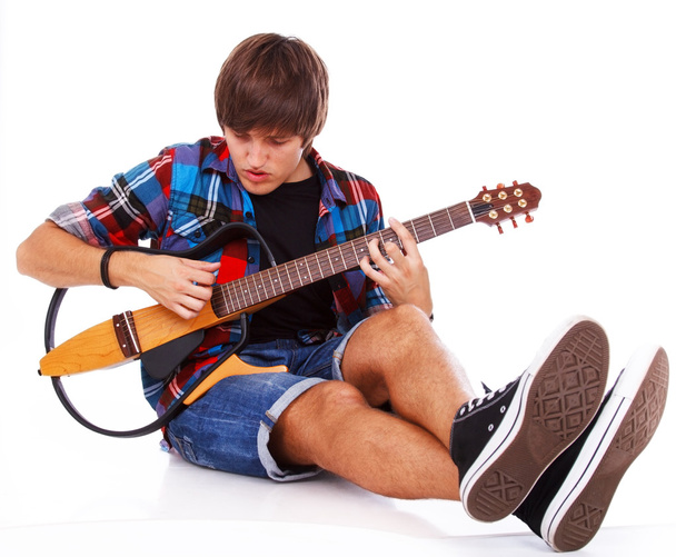 Young punk is playing on cool styled guitar - Photo, Image