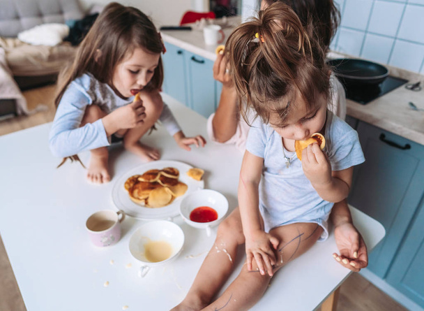 Maman et deux filles mangent des crêpes
 - Photo, image