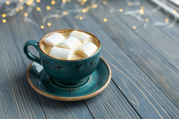Cup of coffee, marshmallow on wooden background. Warm lights. Cozy winter morning. Lifestyle concept. Selective focus. - 写真・画像