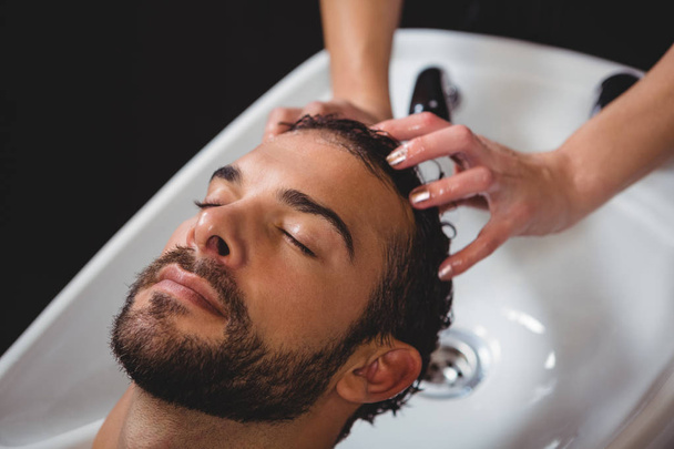 Мужчина моет волосы в салоне
 - Фото, изображение