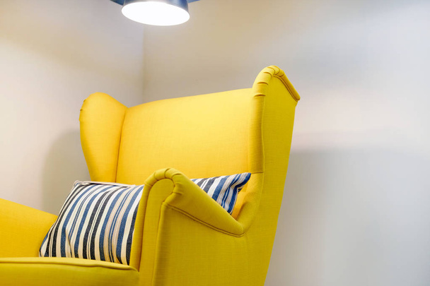 Żółty myagkoe krzesło z poduszką, wysoki, powrót czytanie Lampa nad głową. Wnętrze salonu. - Zdjęcie, obraz