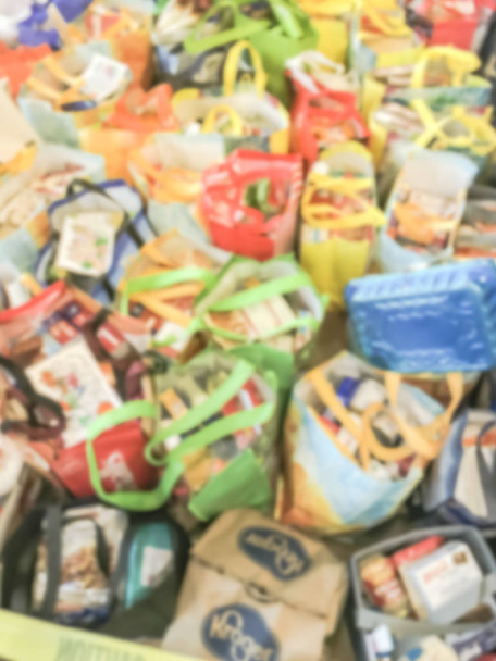 Розмиті абстрактних купу багаторазові tote сумки продуктові упаковані з їжі та іграшки для пожертвування подяки барвисті піддавки подарунки від церкви в Техасі, Америка - Фото, зображення