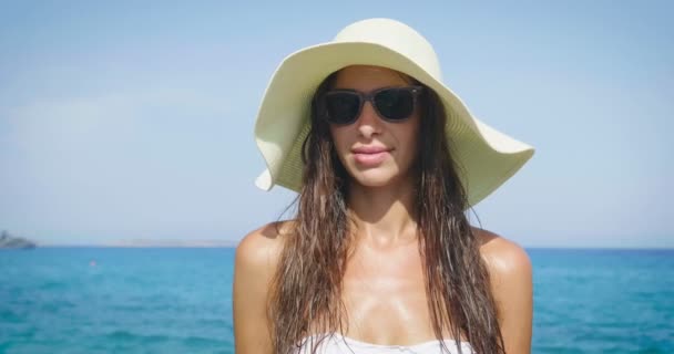 video of woman wearing sun glasses, white summer hat and enjoying sea and pointing finger on virtual display  - Кадры, видео