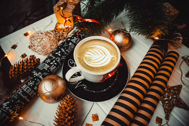 Cup of coffee on a wooden background with christmas toys and paper - Фото, зображення