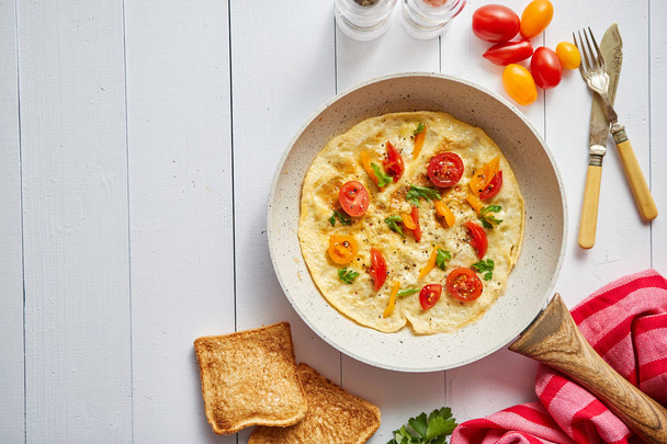 Heerlijke zelfgemaakte ei omelet met tomaten en peterselie - Foto, afbeelding