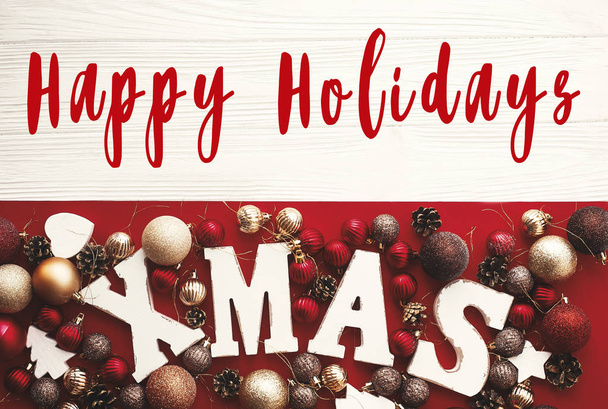 Happy Holidays tekstiä Xmas puinen sana punaisella helyjä ja koristeet maalaismainen valkoinen tausta, tasainen lay. Kauden onnittelukortti. Hyvää joulua ja onnellista uutta vuotta
 - Valokuva, kuva