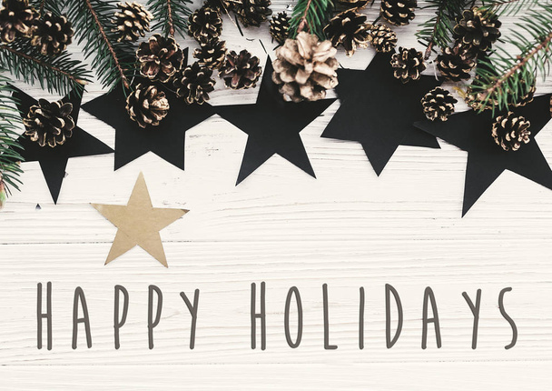 Šťastné svátky text na moderní vánoční ploché ležela zelená jedle větve, zlaté šišky a hvězd. Sváteční přání. Veselé Vánoce a šťastný nový rok - Fotografie, Obrázek