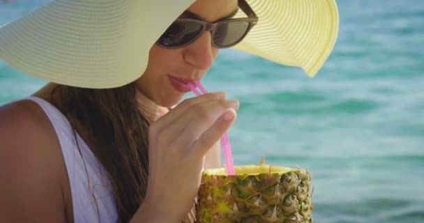 vídeo de la mujer disfrutando de jugo de piña en la playa de arena
  - Metraje, vídeo