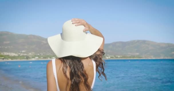 video of woman having vacation on beach and wearing white summer hat  - Footage, Video