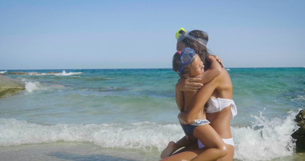 The best moments, the mother with a little daughter are played on the sea, in sunglasses, in swimsuit, sun protection cream, sea and sand background. Concept: love, lifestyle, children, vacations - 映像、動画