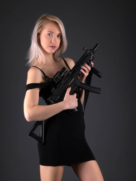 foto del estudio de moda de la hermosa mujer rubia con pistola - Foto, Imagen