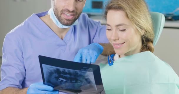 video of dentist doctor man showing x-ray to woman - Záběry, video