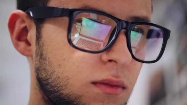 Close-up of a man working on a laptop, reflection a screen with glasses - Filmagem, Vídeo
