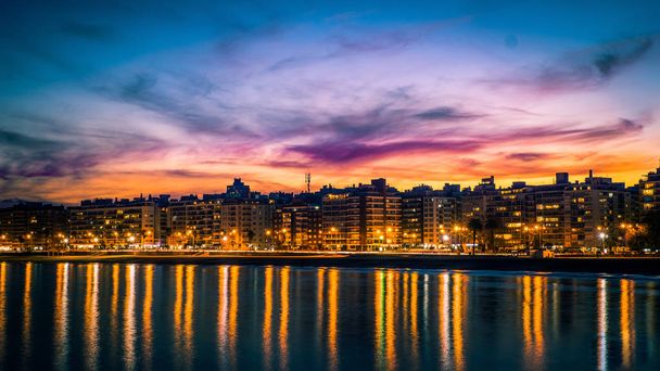Zonsondergang over Montevideo, contrast van kleuren en reflectie van het licht in het water - Foto, afbeelding