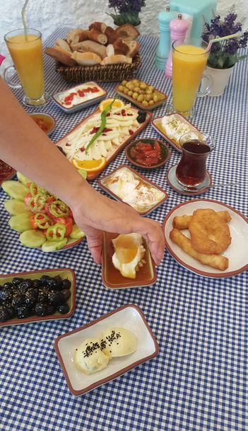 伝統的なトルコ式の朝食、様々 な料理のテーブルの女性のトリミング ビュー. - 写真・画像
