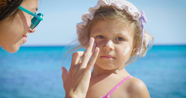 Portret van mooie meisje plezier op de zee, schattige lachende in panama, bescherming zonnebrandcrème, achtergrond van zee blauw water en rotsen. Concept: kinderen, jeugd, zomer, vrijheid, kids, baby - Video