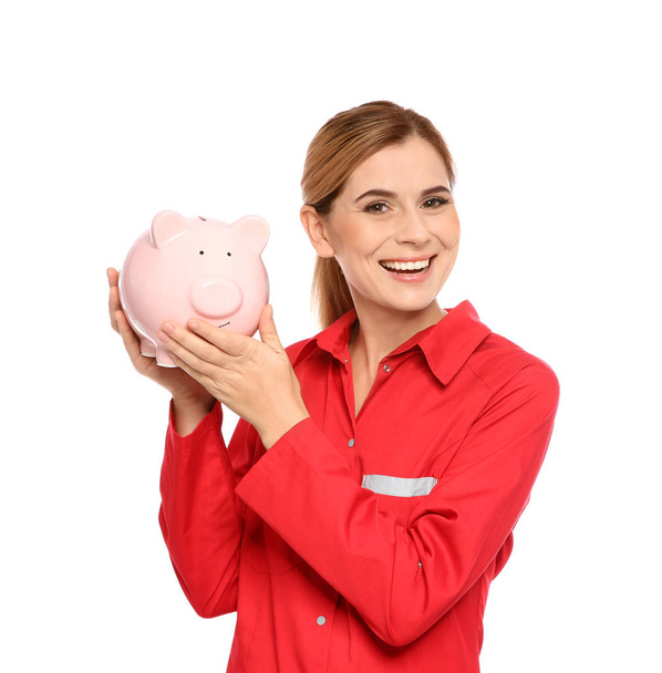 Portrait of female emergency doctor with piggy bank on white background - Foto, Bild