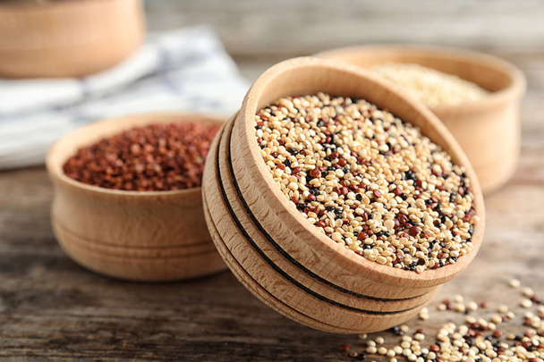 Bowl with mixed quinoa seeds on wooden table - 写真・画像