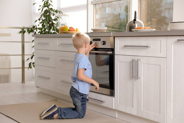 Little boy baking something in oven at home - Foto, imagen