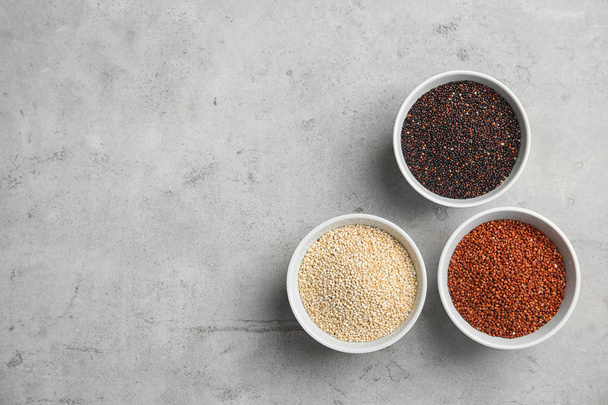 Flat lay composition with different types of quinoa and space for text on grey background - Photo, image