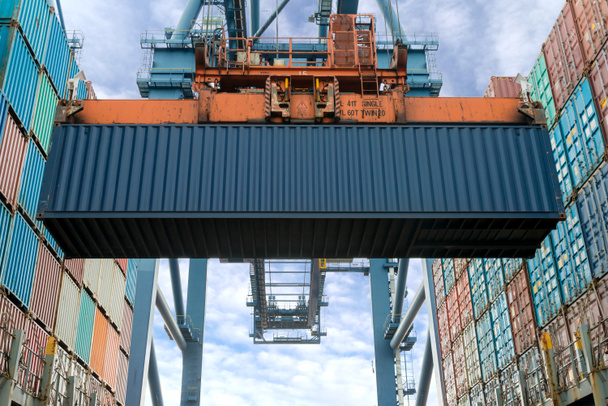 Endüstriyel vinç konteyner bir kargo yük gemisiyle yükleniyor. Konteyner gemisi ithalat ve ihracat iş logistic şirketi. Sanayi ve Ulaştırma kavramı. - Fotoğraf, Görsel