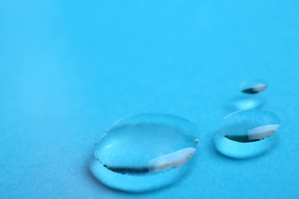 Pure water drops on color background, closeup. Space for text - Foto, imagen