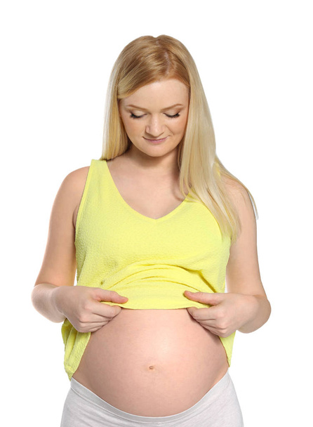Beautiful pregnant woman showing her tummy on white background - Фото, зображення