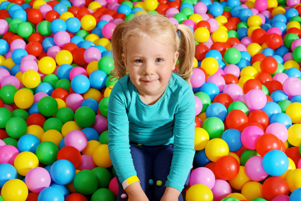 Cute child playing in ball pit indoors - Fotografie, Obrázek