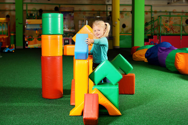 Aranyos gyerek játszik a színes építőkockák beltéri - Fotó, kép