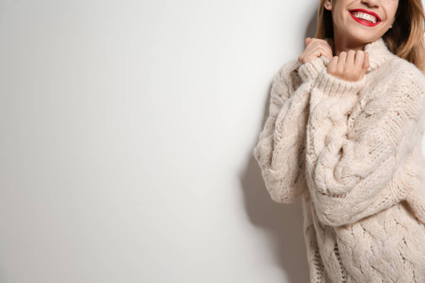 Beautiful young woman in warm sweater on white background. Space for text - Foto, afbeelding