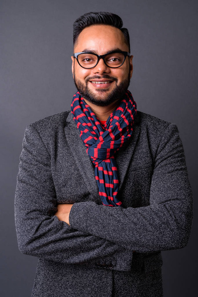 Joven empresario indio barbudo contra fondo gris - Foto, imagen