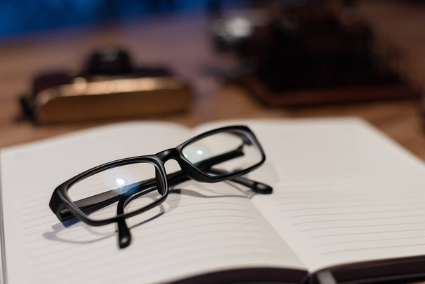 glasses and notebook on the table with nobody, concept of working at home - 写真・画像