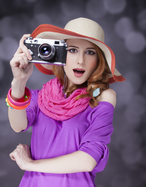 Vicces vörös hajú lány kalapban, a kamera és a háttérben a bokeh - Fotó, kép